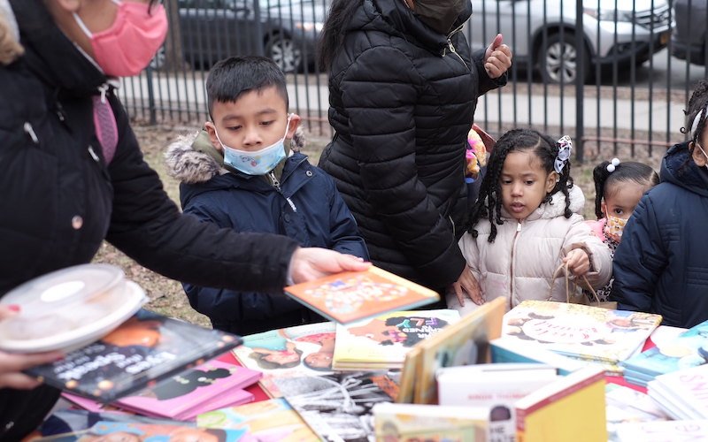 Wellbeing Jamboree with Lewis Latimer House Museum 2 Three children and two caregivers pick out children's books from a round table
